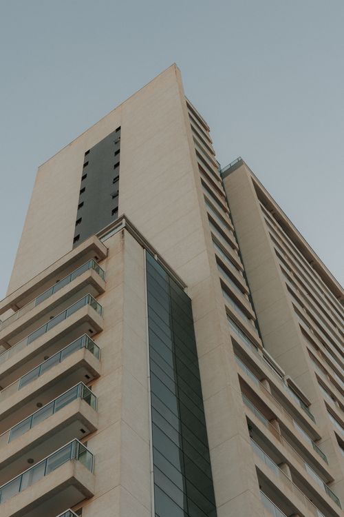Free Perspective view of a tall, modern high-rise building against a clear sky. Stock Photo