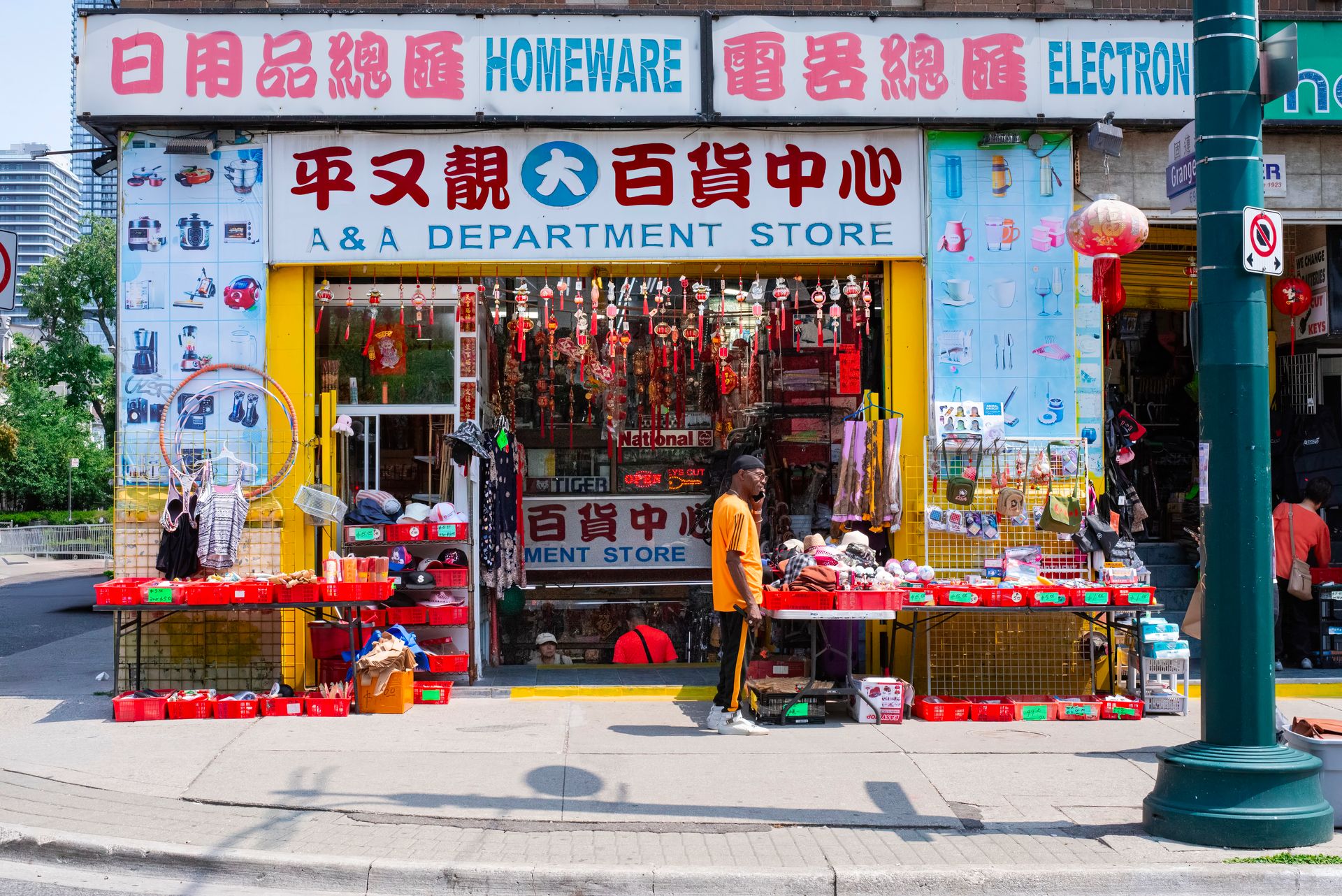 Colorful exterior view of an Asian department store with a pedestrian passing by on a sunny day.