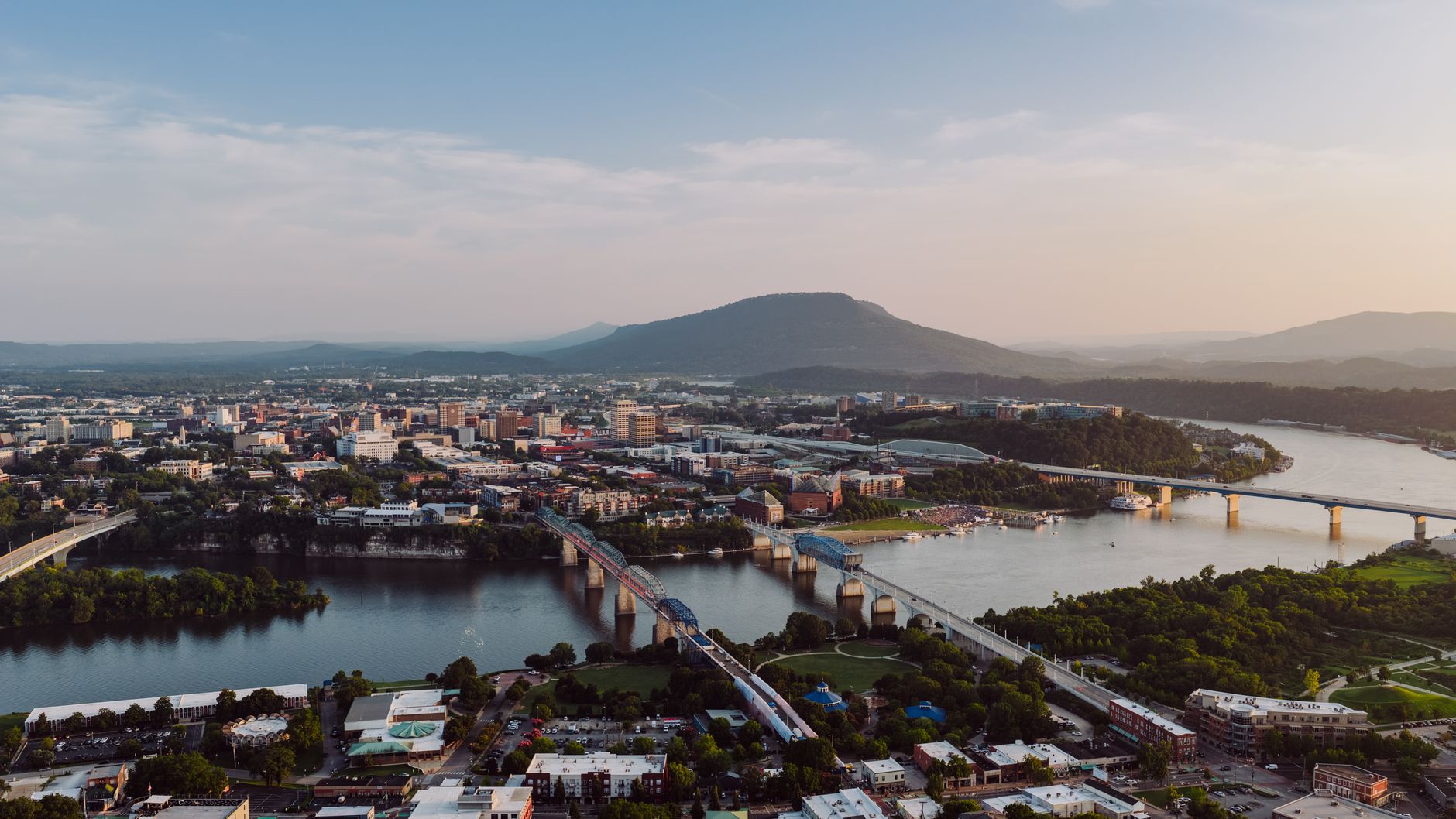 Breathtaking aerial view of Chattanooga, Tennessee skyline with iconic bridges and river at sunset.