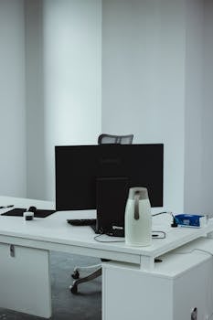 Clean and modern office desk with computer and accessories in a minimalist style.