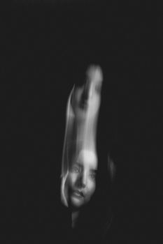 Ethereal black and white portrait with blurred motion effect, creating a mysterious and artistic mood.