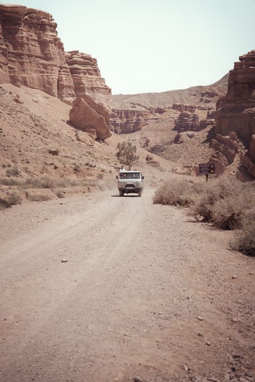 Free A vintage van travels through the rugged landscape of Charyn Canyon, Kazakhstan. Stock Photo