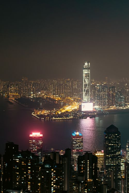 Free Stunning night view of Hong Kong skyline featuring illuminated skyscrapers and water reflections. Stock Photo