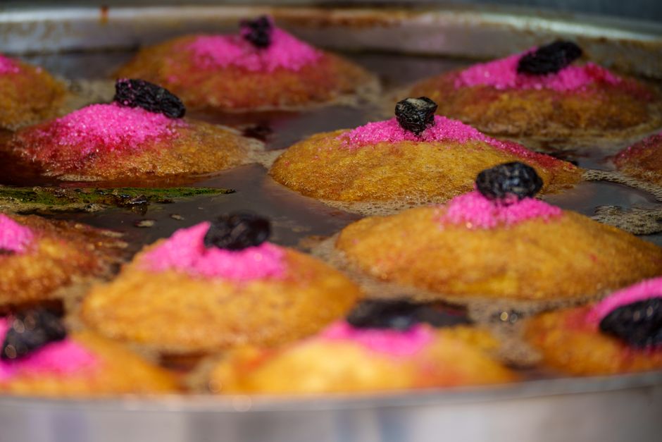 Delicious traditional Guatemalan chilacayote desserts frying with vibrant pink sugar and prunes.