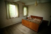 这间迷人的乡村风格卧室配有木制家具，自然光线透过窗户洒入室内