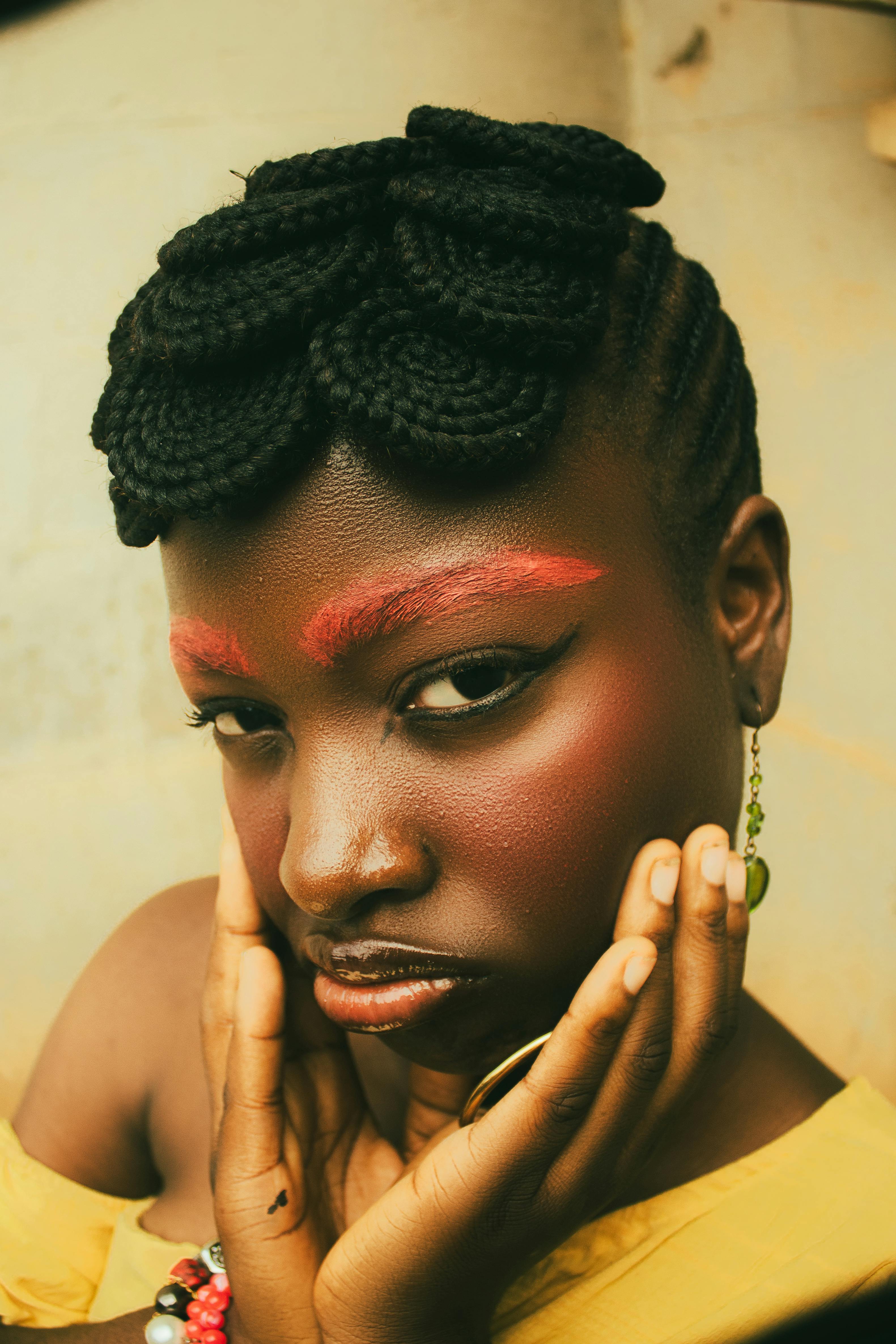 Striking portrait of a woman with bold makeup and unique hairstyle, showcasing artistic expression.