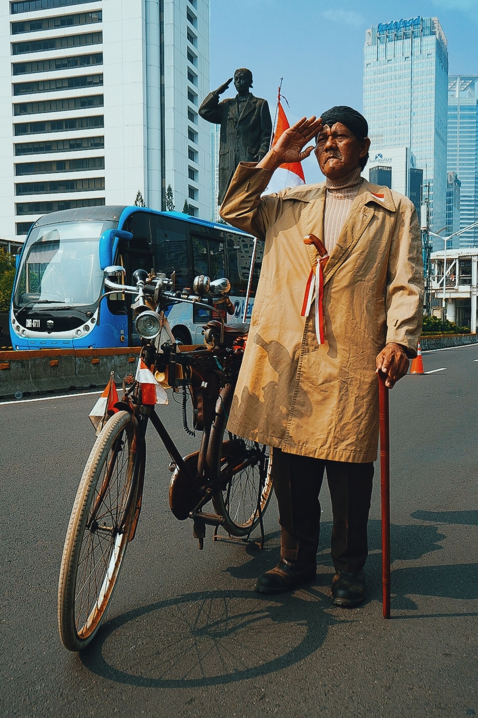 Elderly Man Saluting on Jakarta Street with Bicycle