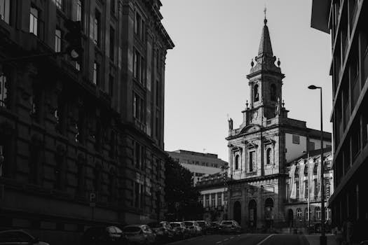Black and white photo of a historic church and street in Porto, capturing classic architecture.