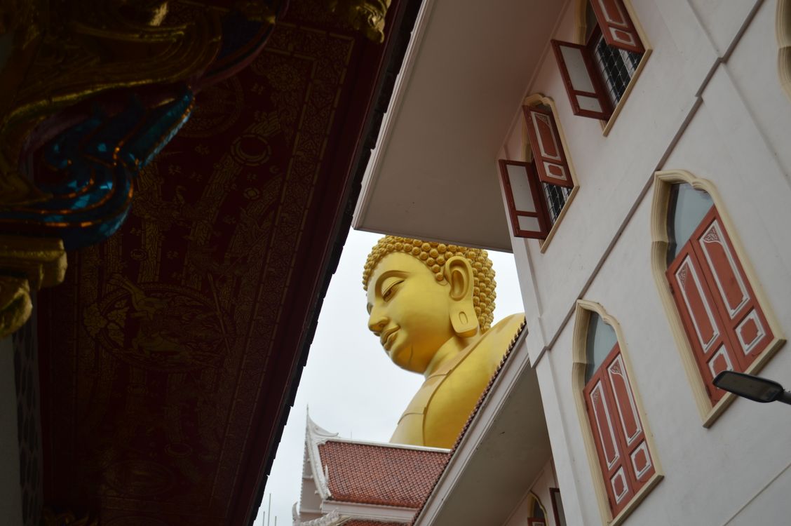 Golden Buddha Statue Amidst Traditional Architecture · Free Stock Photo