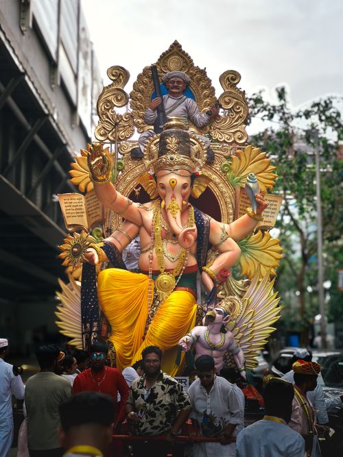 Free Colorful Ganesh idol during a festive street procession in Mumbai's Ganesh Chaturthi celebration. Stock Photo