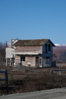 An abandoned wooden house in a rural landscape of Tierra del Fuego, Argentina.