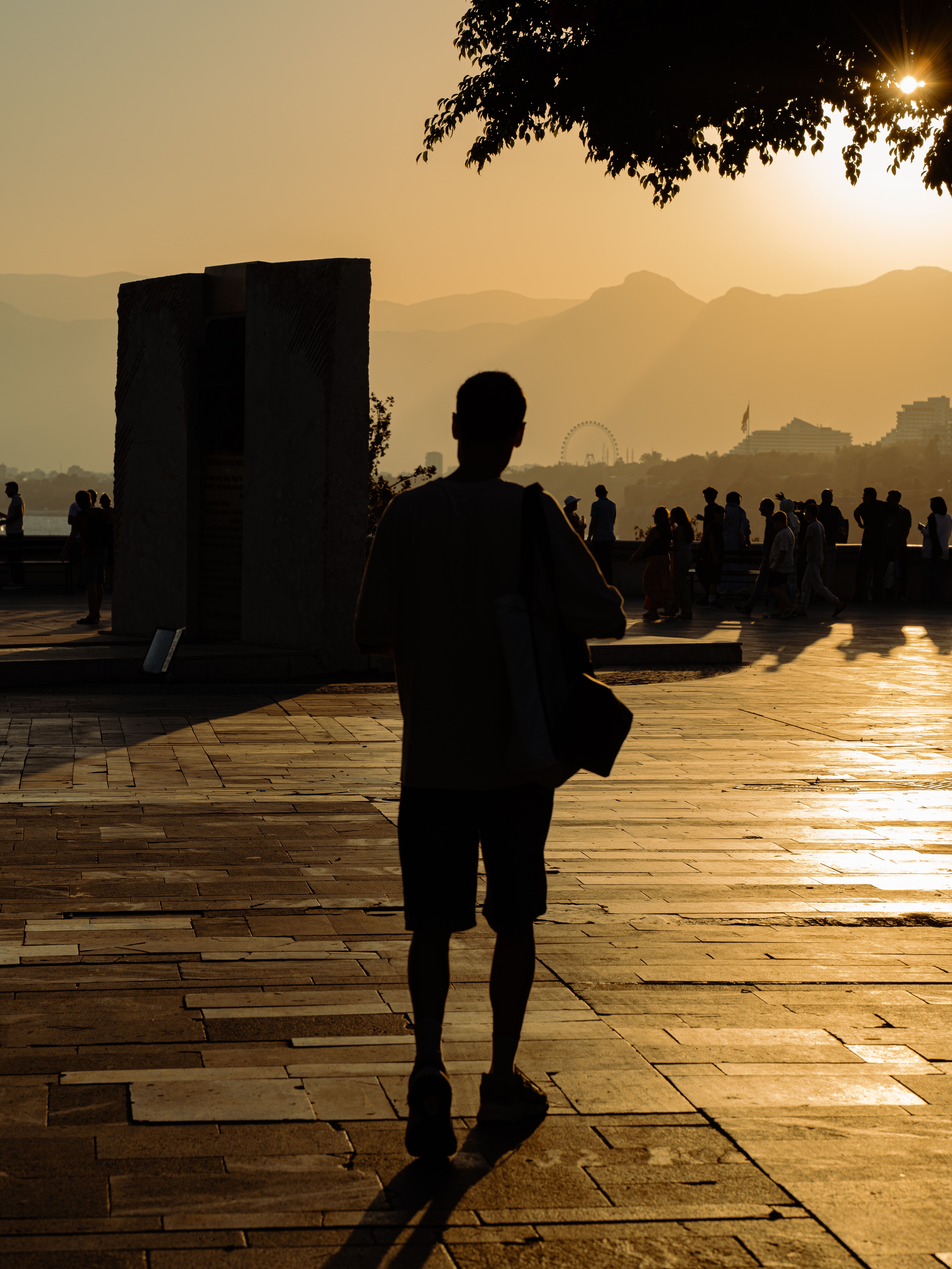 Silhouette walking toward people gathered at a golden horizon