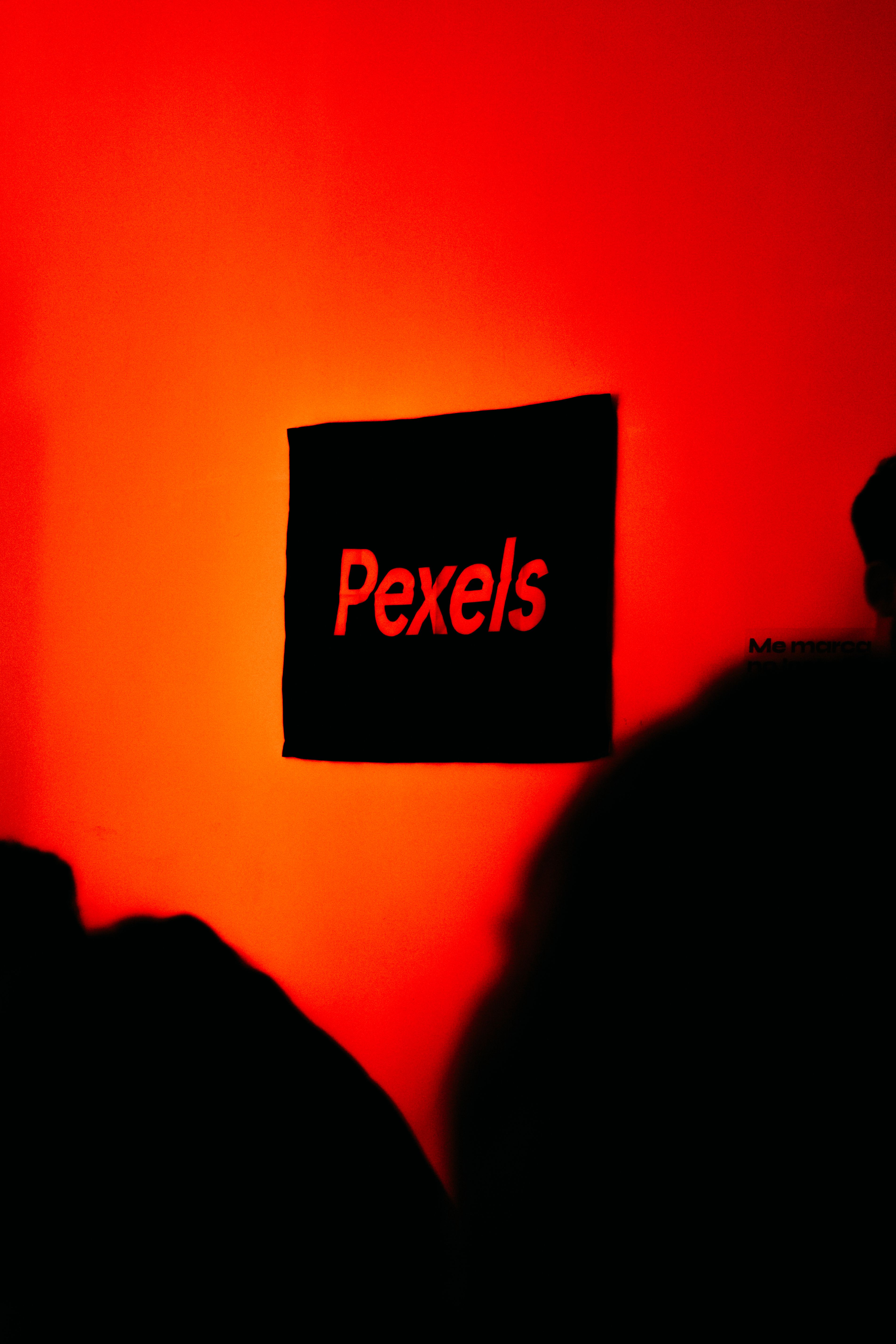 A striking red wall with the Pexels logo, creating a bold and modern aesthetic indoors.