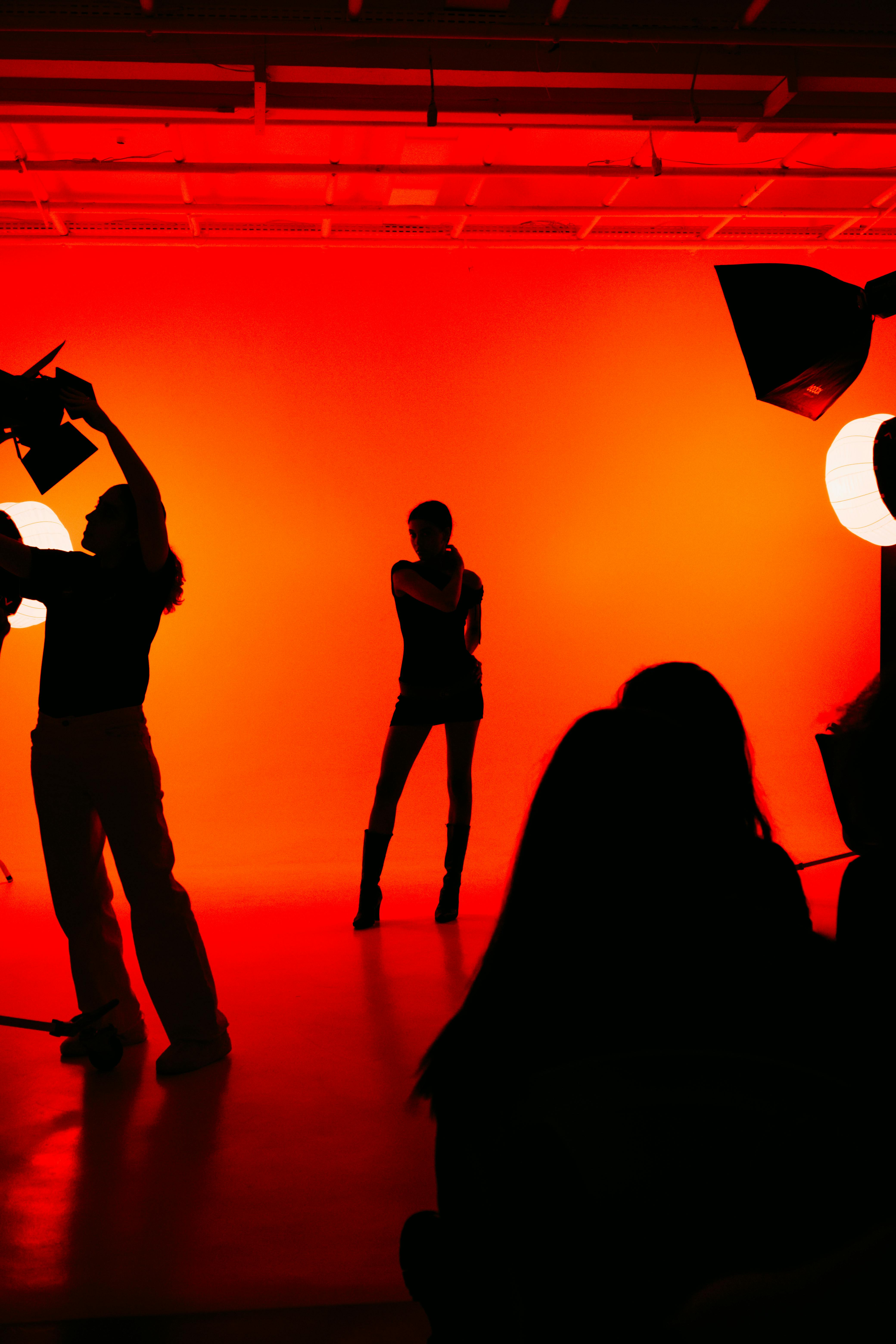 Ücretsiz Dramatik ışıklandırmanın eşlik ettiği canlı bir stüdyo fotoğraf çekiminde şık silüet. Stok Fotoğraflar