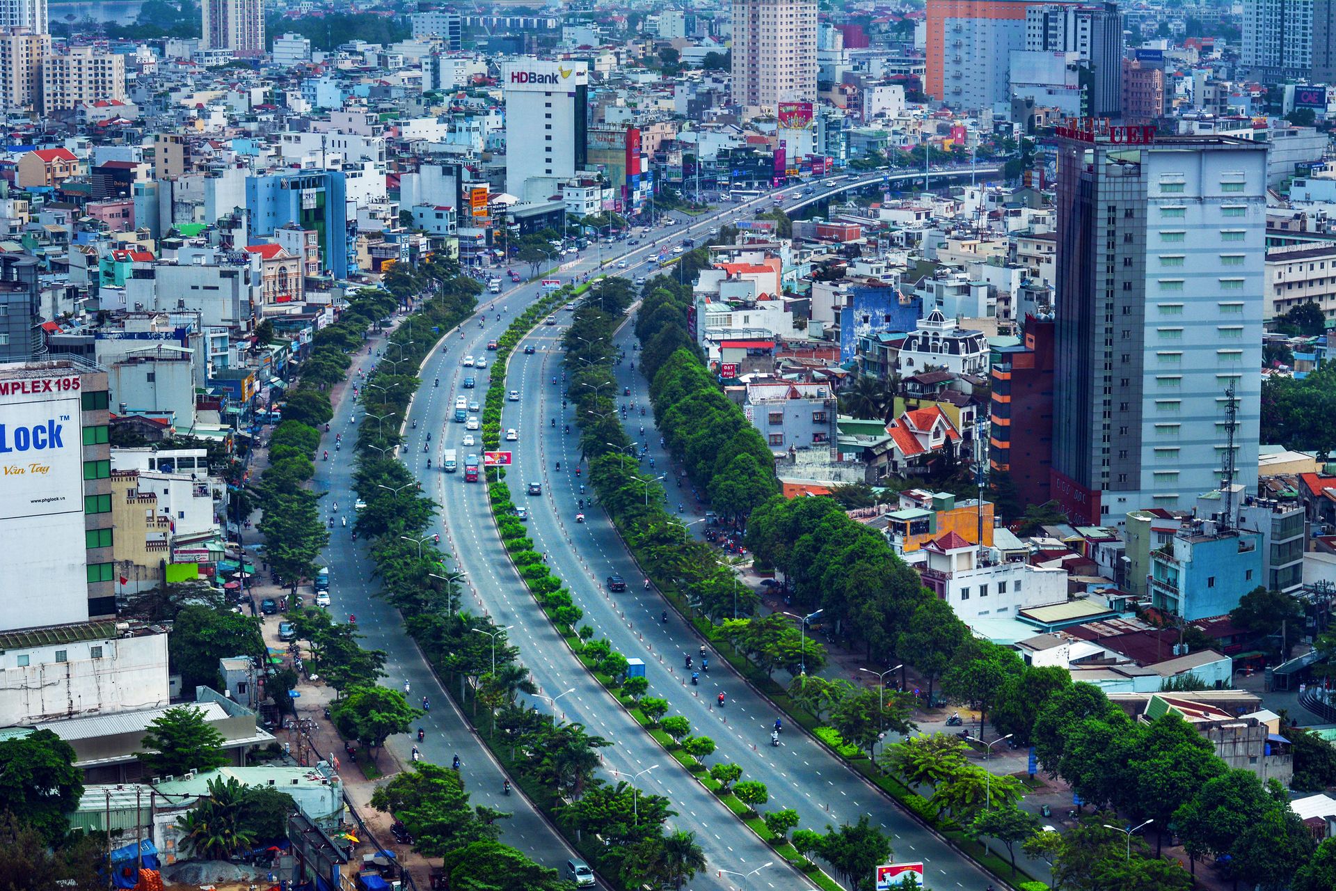 Aerial photograph of a bustling city with high-rise buildings and a major thoroughfare in Vietnam.