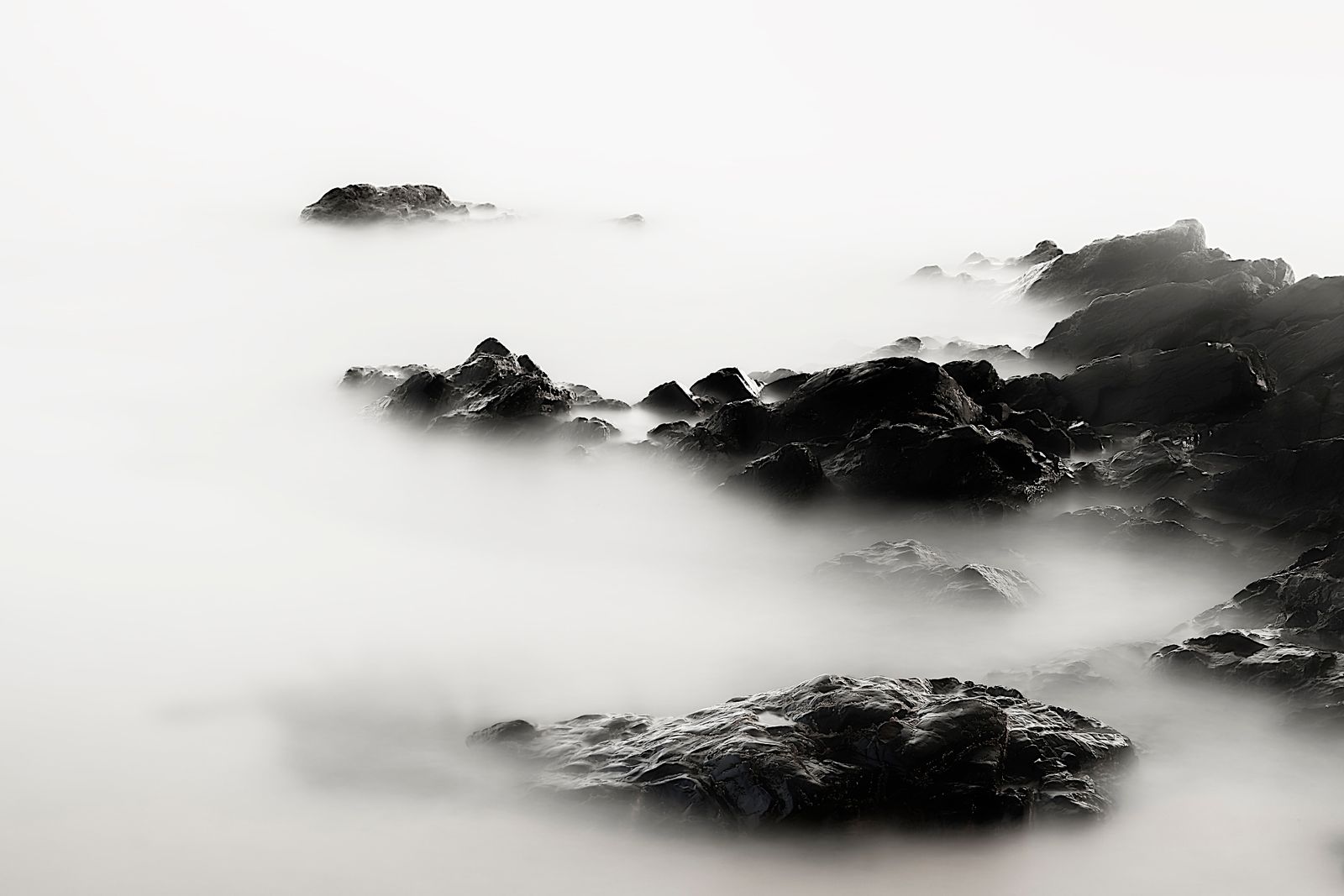Mist over a rocky shoreline, photo by Gilles QUERTIER on Pexels