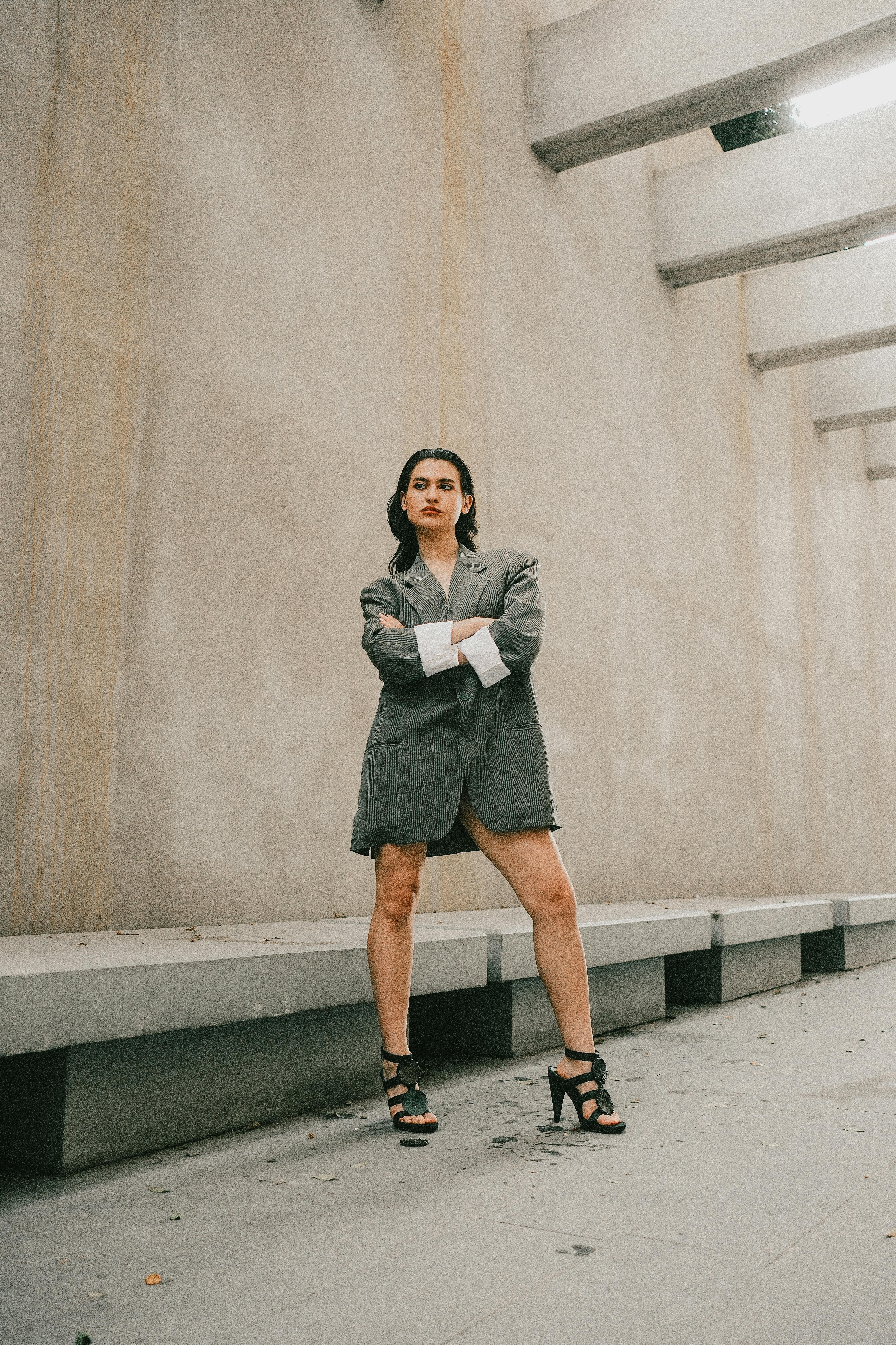 Confident woman posing in an oversized blazer in a minimalist urban environment.