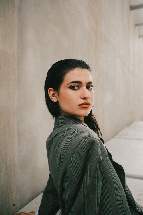 Free A woman with a confident look poses in an elegant blazer, capturing a modern and fashionable essence. Stock Photo