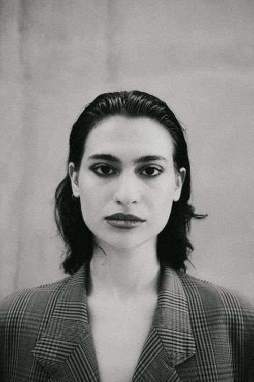Free Elegant black and white portrait of a young adult in a checkered blazer. Stock Photo