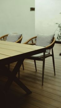 Stylish wooden indoor patio setup with chairs and table, perfect for relaxation or social gatherings.