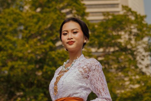 Free Young woman in traditional attire posing outdoors against a city backdrop. Stock Photo