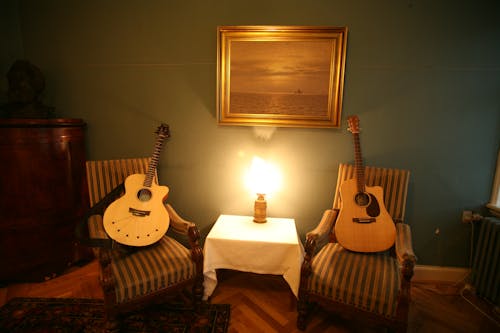 Two Brown Acoustic Guitars on Chairs