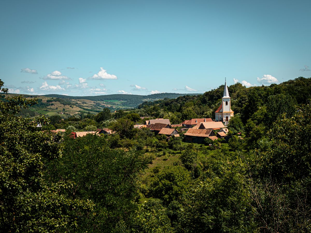 Sat cu turn de biserica pe un deal verde, langa Sibiu