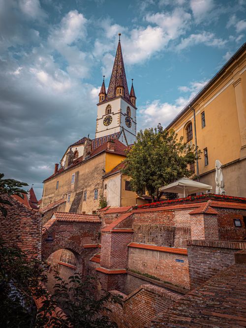 Free Beautiful view of Sibiu's Lutheran Cathedral with dramatic skies at sunset, showcasing iconic Romanian architecture. Stock Photo