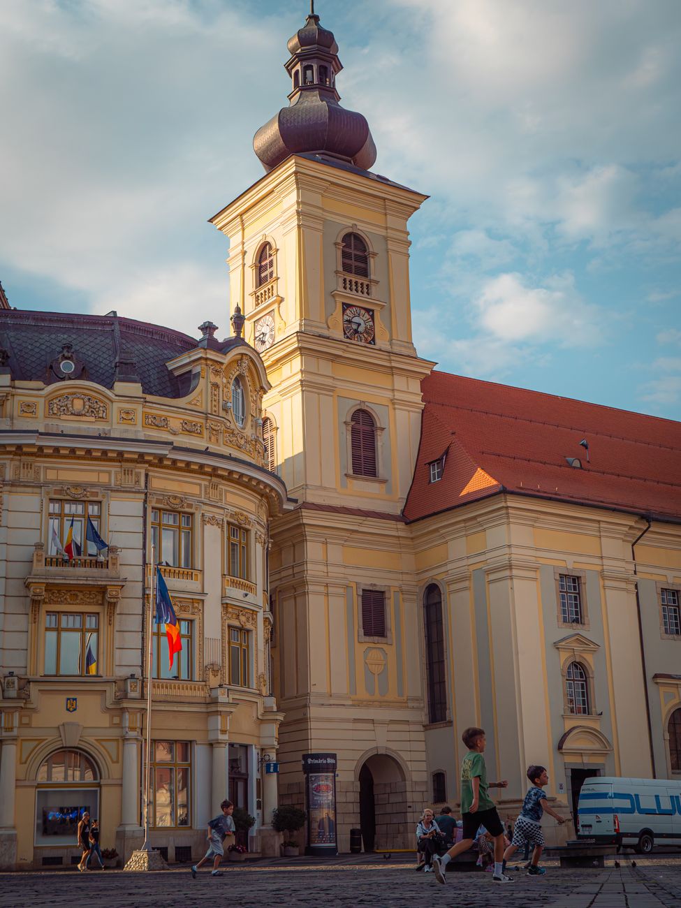 O scenă din centrul Timișoarei cu oameni participând la evenimente O scenă din centrul Timișoarei cu oameni participând la evenimente