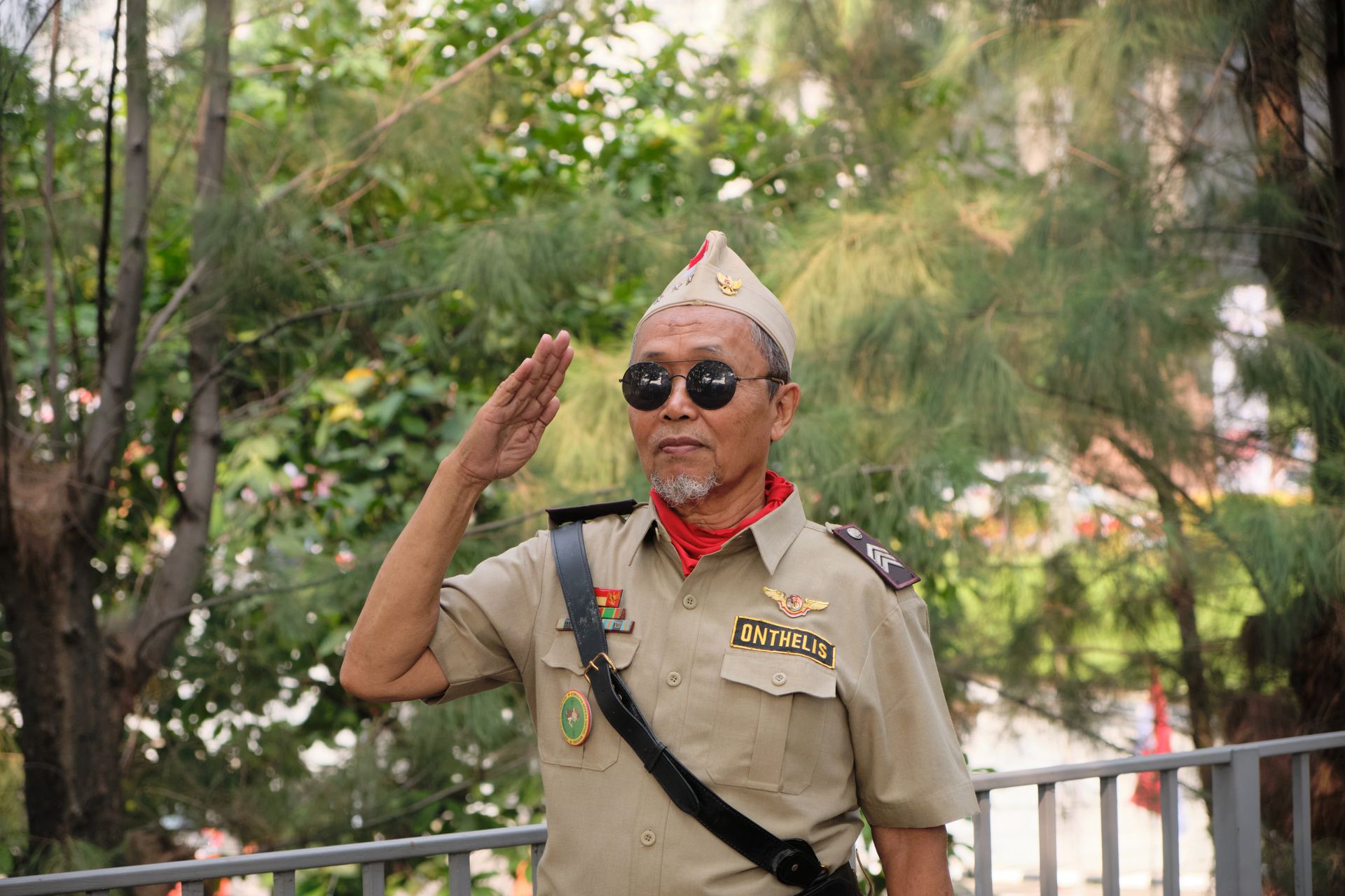 Portrait of Indonesian veteran saluting in Jakarta park.