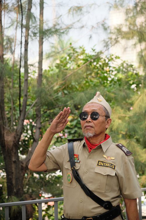 Free Elderly Indonesian veteran saluting outdoors, symbolizing patriotism and nationalism. Stock Photo