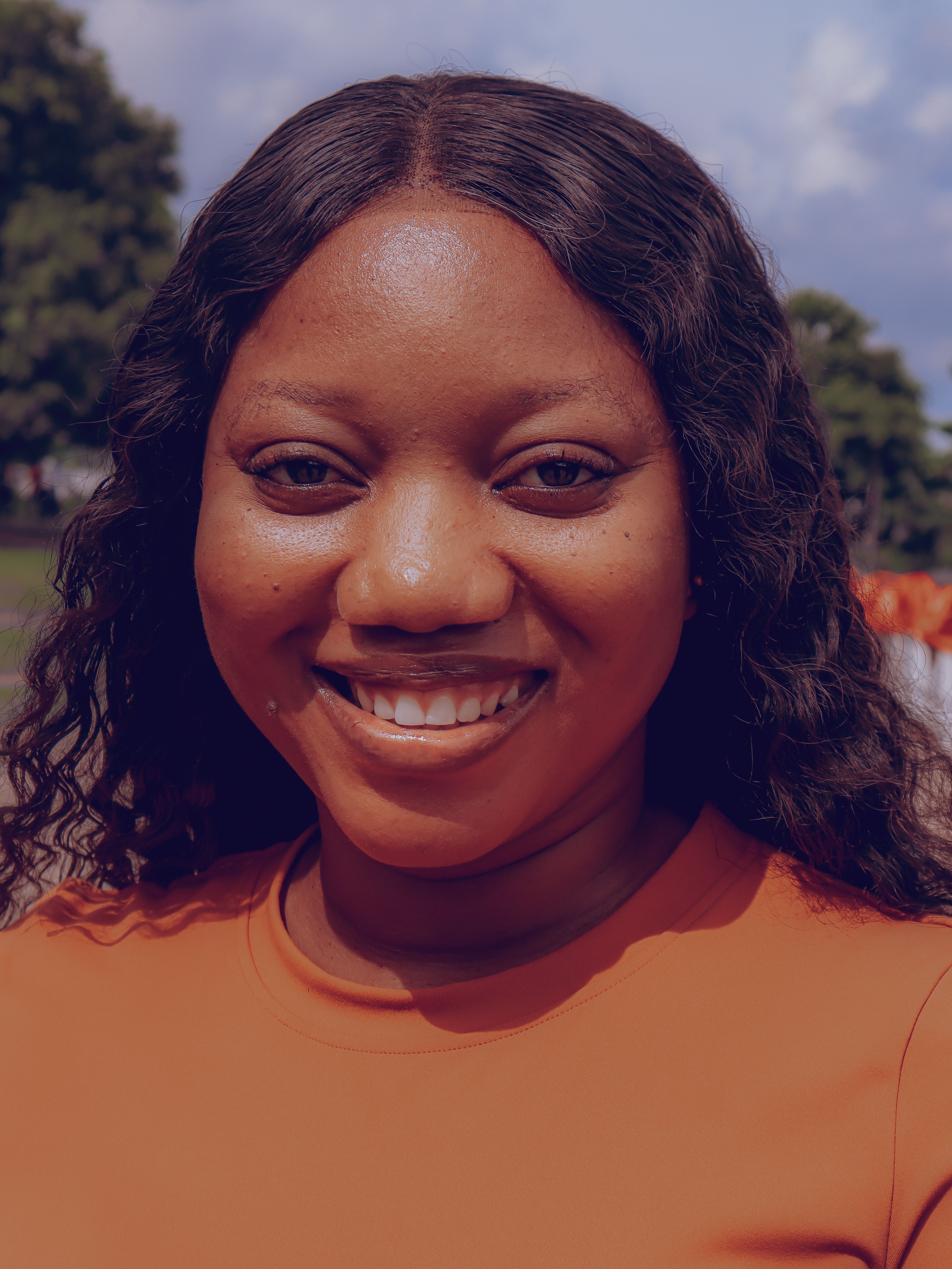 Portrait of a smiling woman in an outdoor park in Abuja, Nigeria.