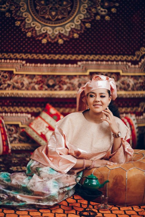 Free Woman in elegant Nigerian attire sitting in a beautifully decorated room. Stock Photo