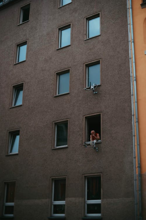 Person in simple apartment building window