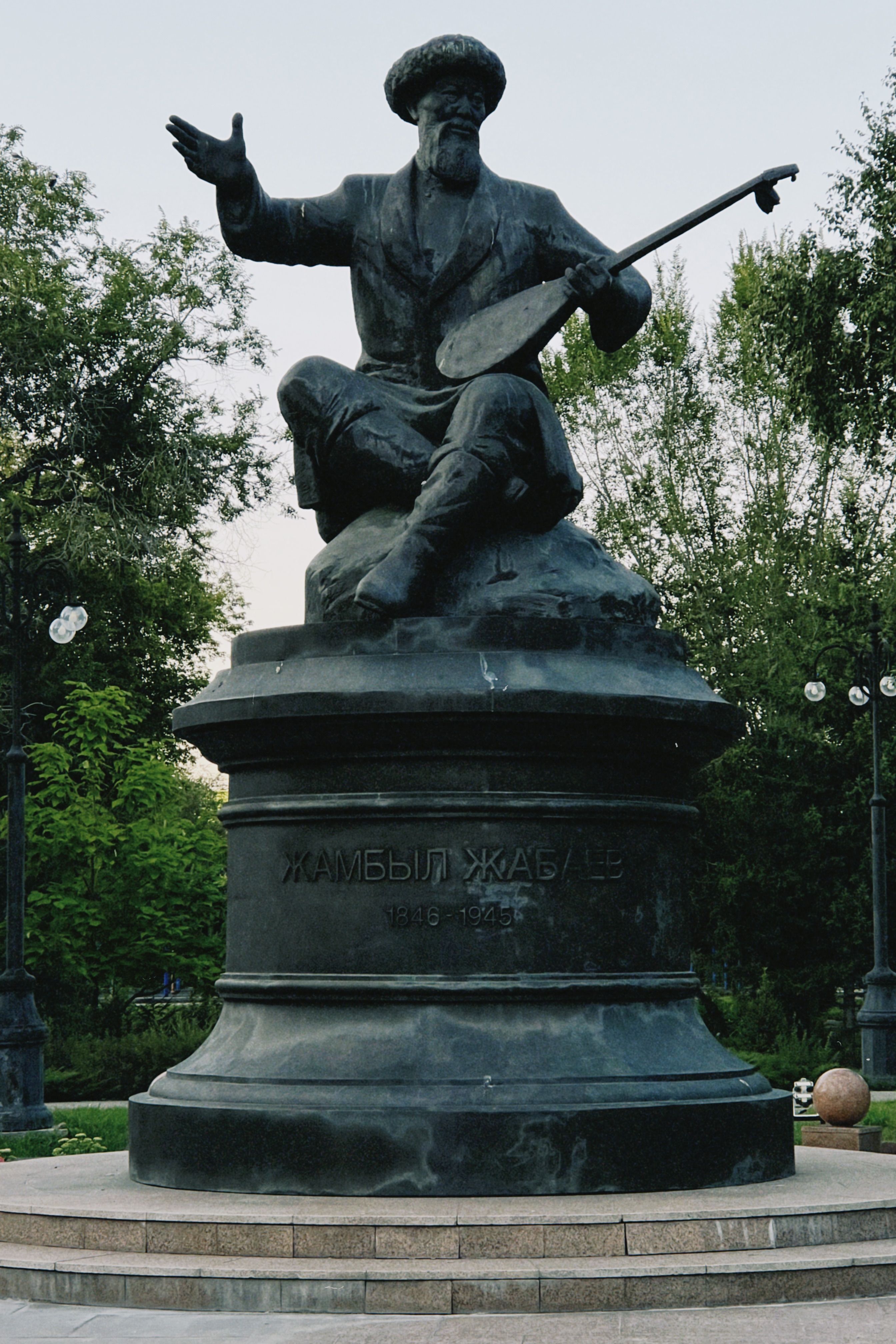 Bronze statue of Zhambyl Zhabayev playing a dombra in Oskemen, Kazakhstan.