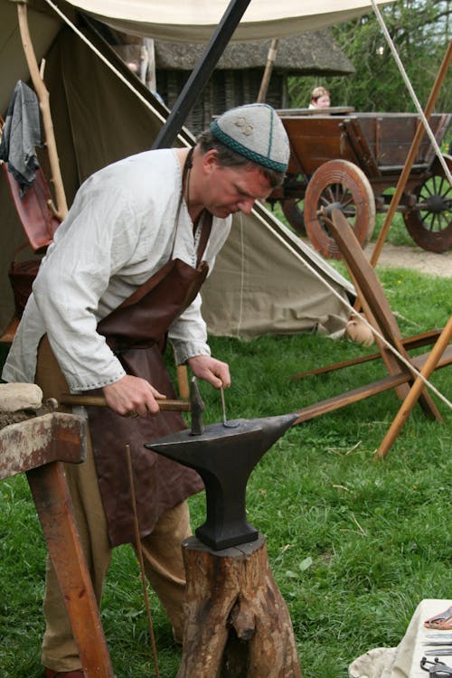 Man Holding a Hammer in Front of Anvil