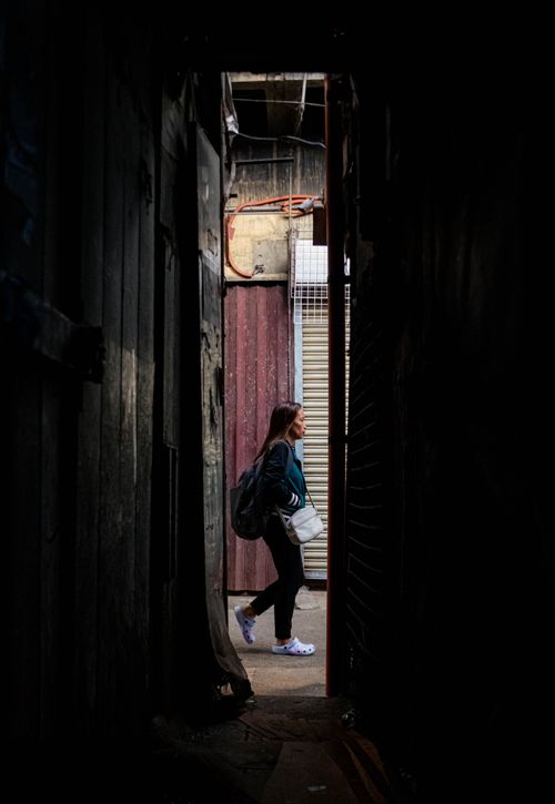 Free A person walking through a narrow, dark alleyway in Baguio City, Philippines. Stock Photo