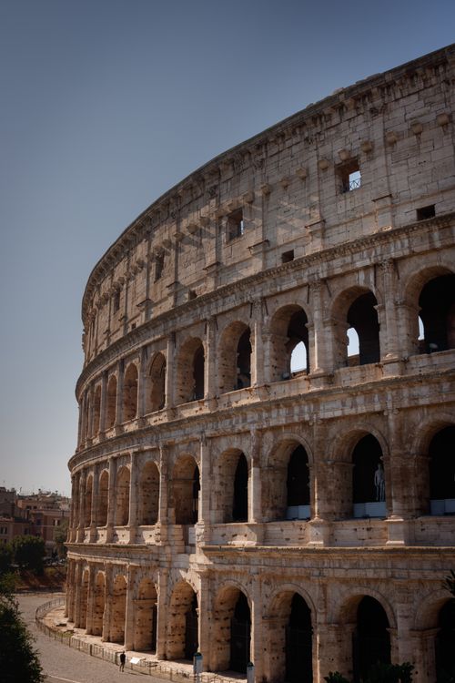 Free A stunning image of the Colosseum under a clear blue sky, highlighting its historical architecture. Stock Photo