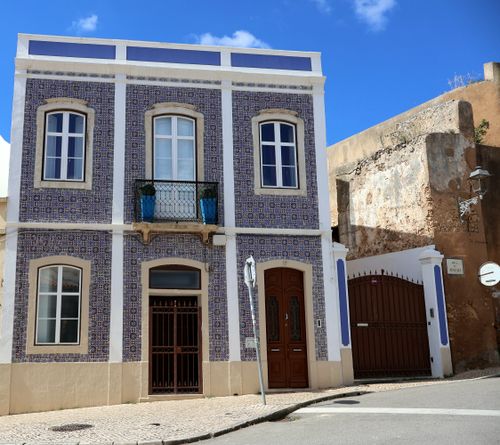 Free Beautiful blue tiled house with classic windows in a sunny Portuguese street. Stock Photo