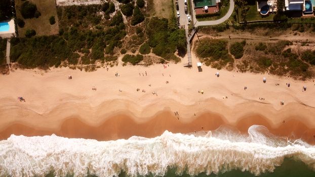 Stunning aerial photo of Balneário Camboriú beach with waves and sunbathers.