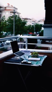 A peaceful balcony setup with a laptop and grapes, ideal for remote work.