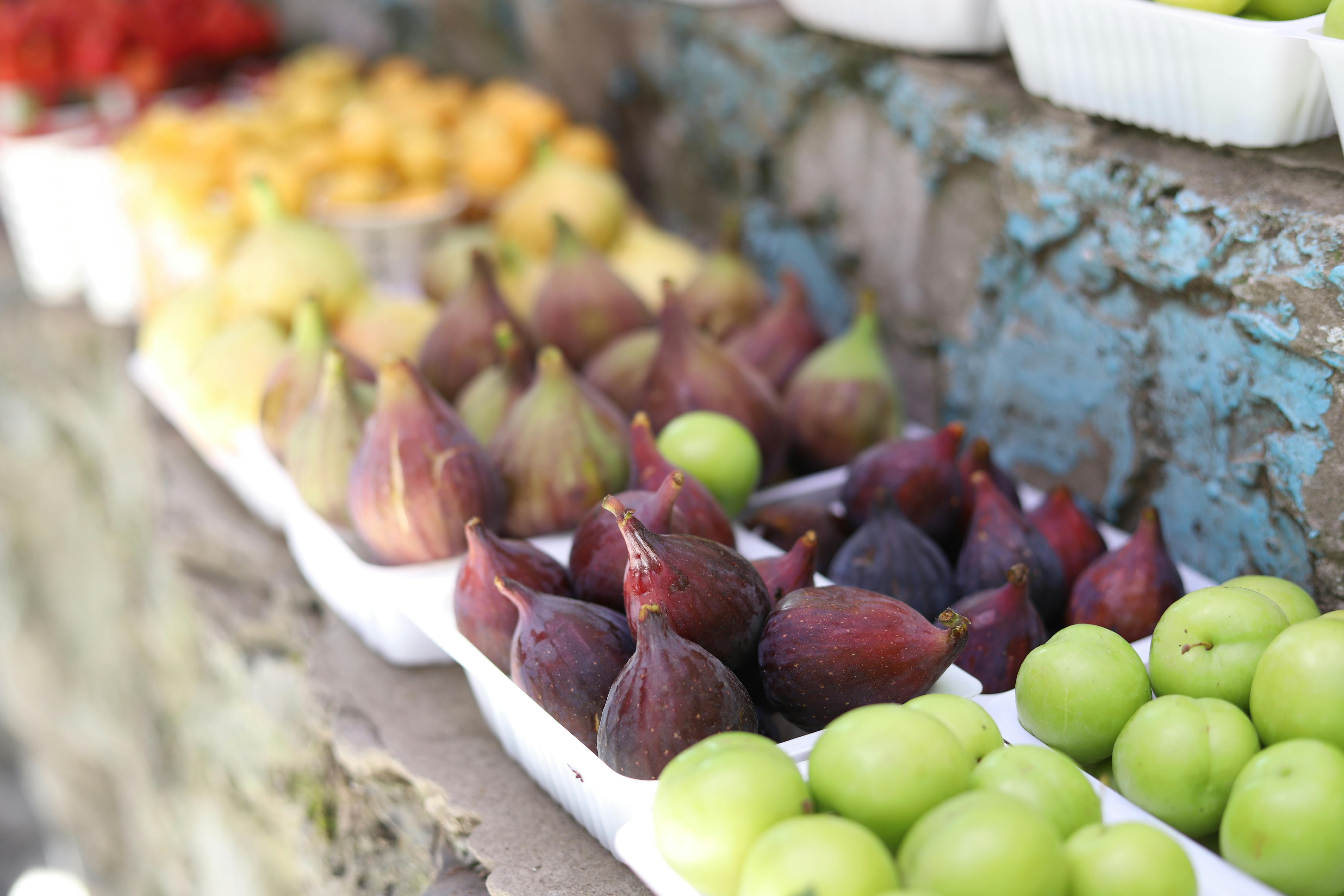 Close-up of figs and various fruits in a colorful market display.