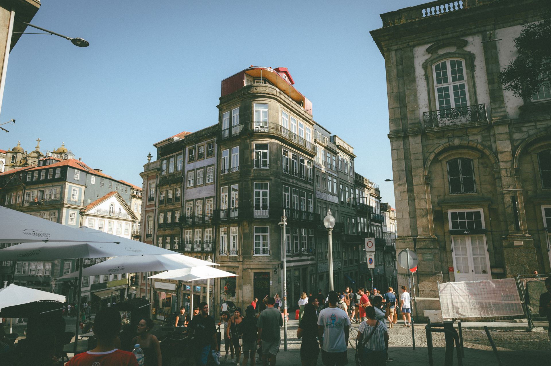 Street scene with historic European architecture and people exploring the area on a sunny day.