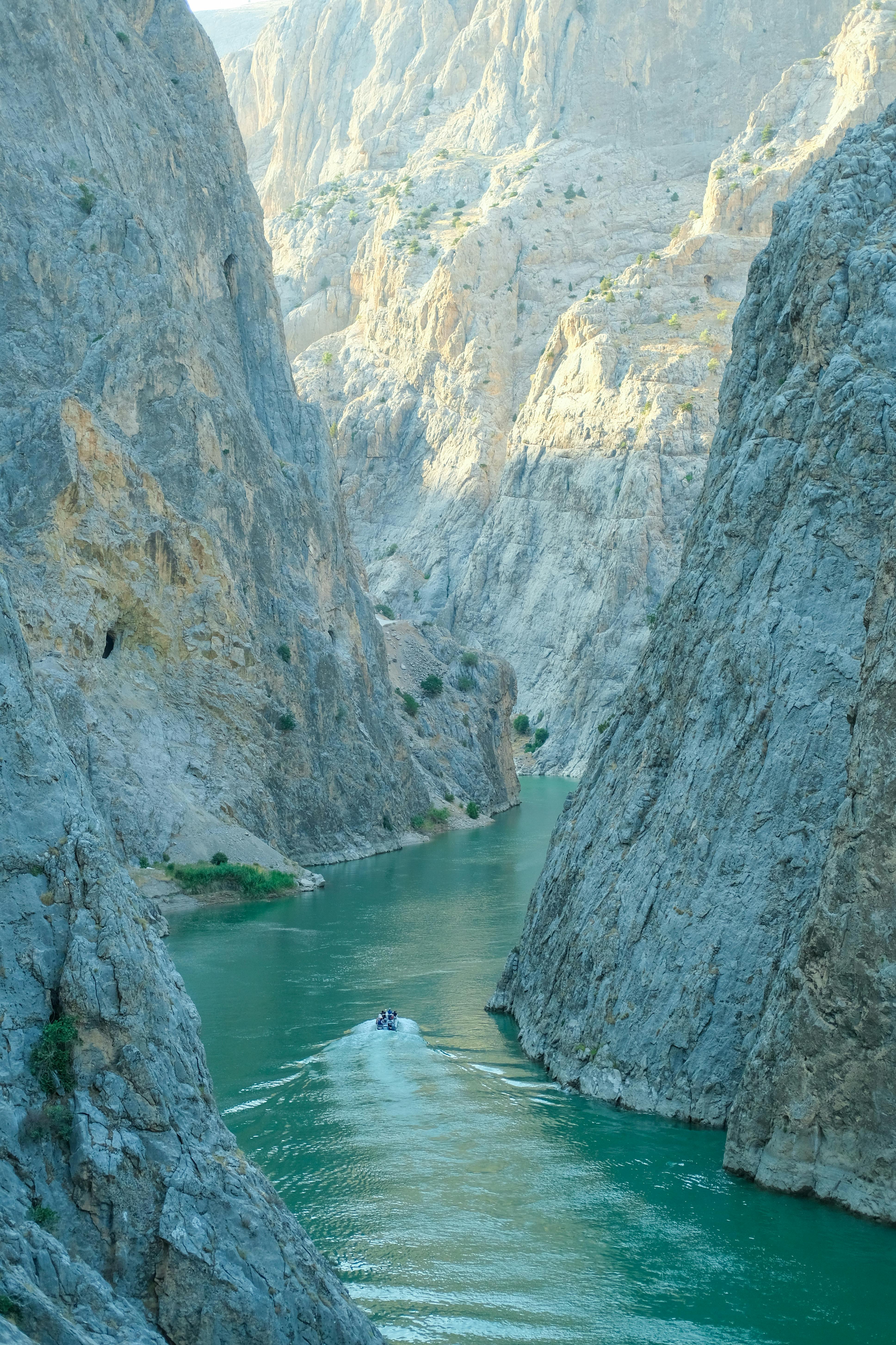 Explore the stunning views of Karanlık Canyon with a boat gliding through the Euphrates River.