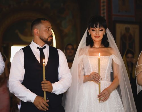 Free Elegant church wedding with bride and groom holding candles, captured in a classic style. Stock Photo