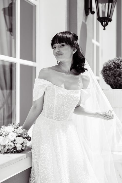 Free Graceful bride in white dress with bouquet in black and white setting. Stock Photo