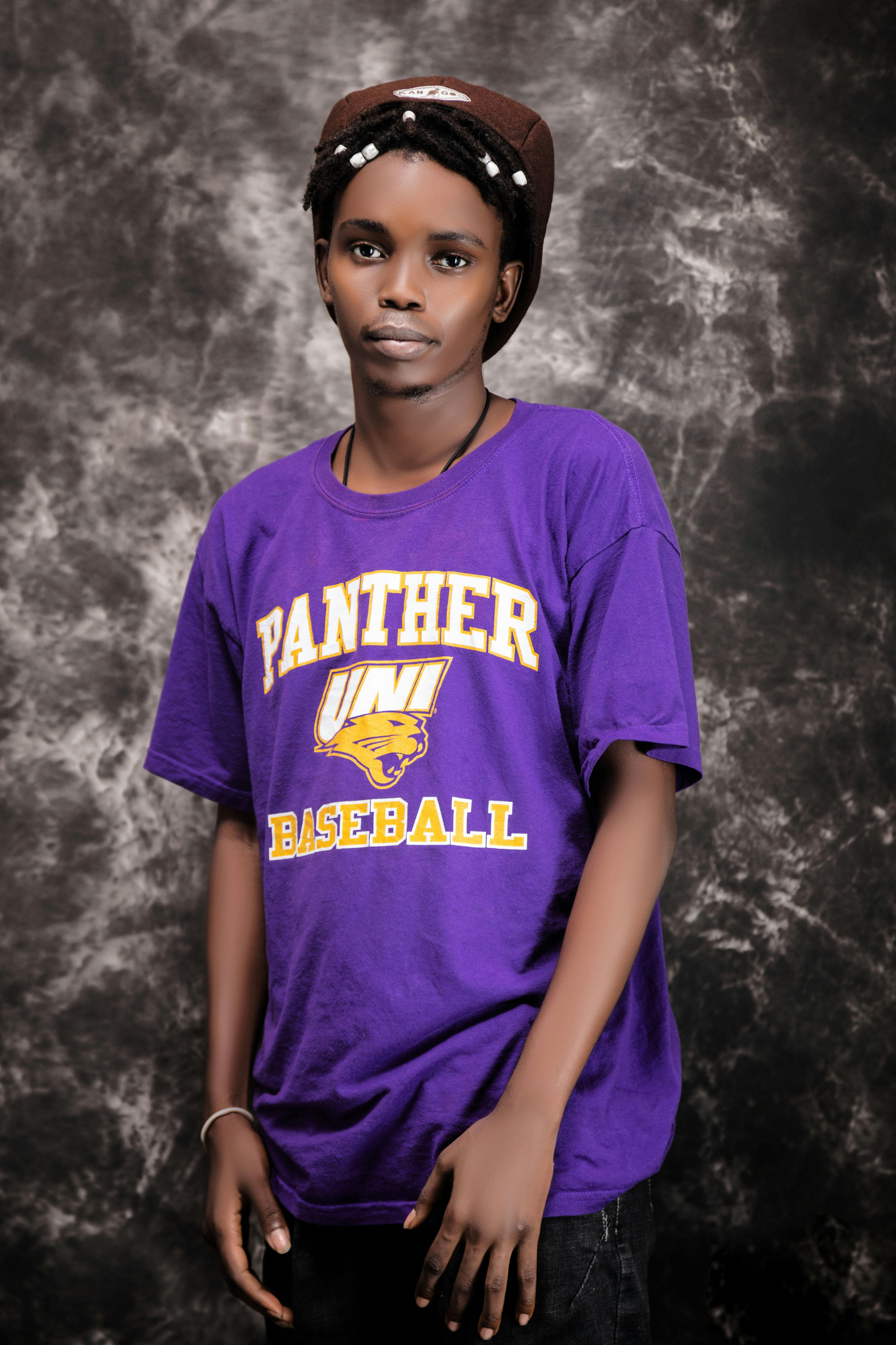 De franc Adult jove elegant amb una samarreta estampada, expressant confiança i carisma sobre un fons texturat. Foto d'estoc