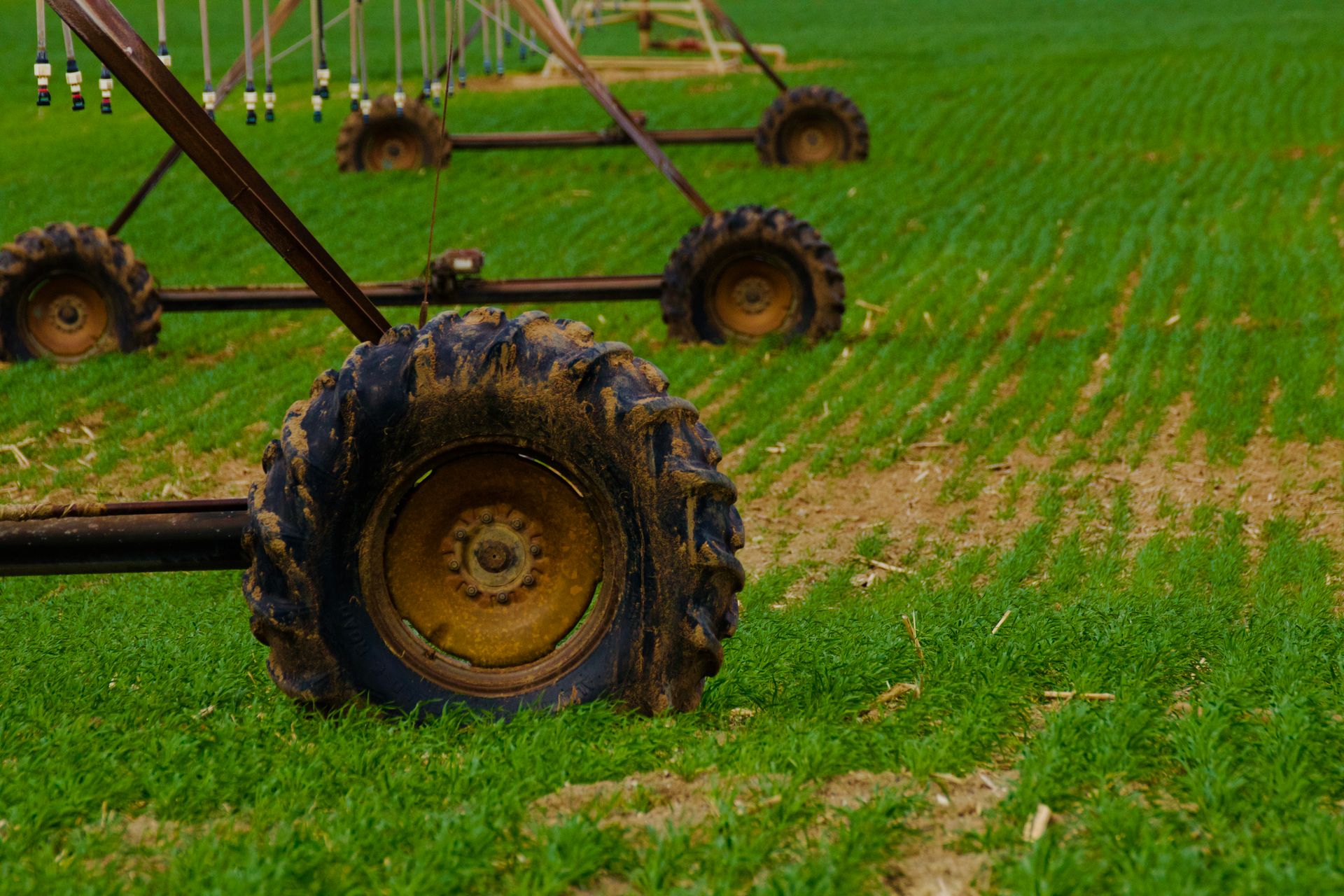 Detailed view of agricultural irrigation system wheels on a green farm field.