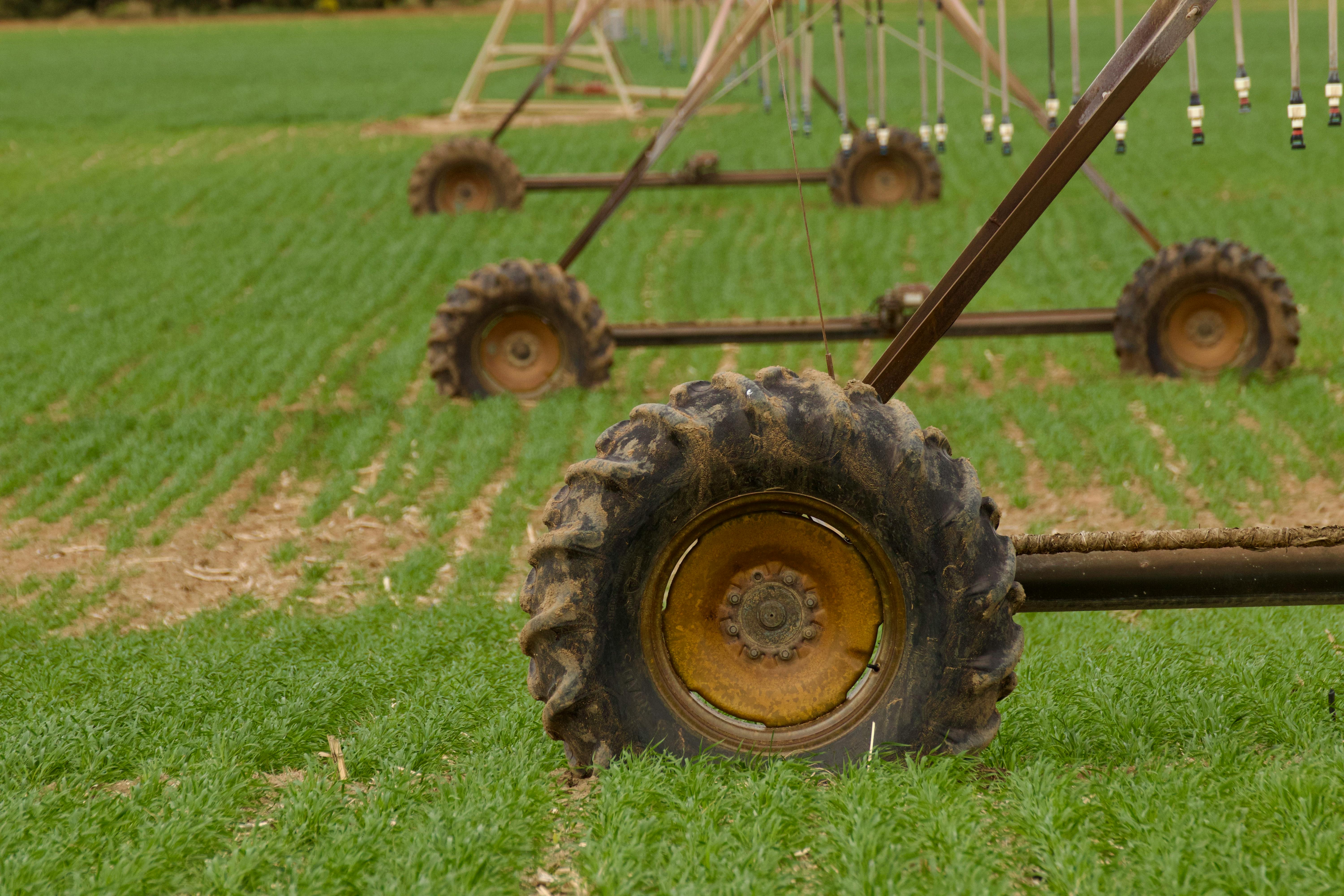 Close-up of irrigation machinery wheels on a green field, illustrating efficient farming and agriculture.