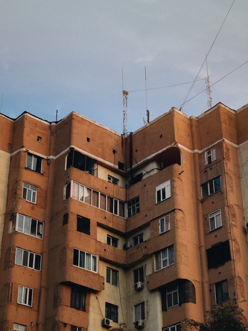 Free Old apartment building with antennas on a clear day, showcasing vintage architecture. Stock Photo